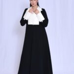 An elegant black blazer featuring white taffeta sleeves and collar.