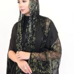 A luxurious black and gold lace abaya featuring shimmering foil chiffon.
